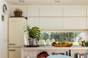 Dream house on Jose Ignacio Lagoon في خوسيه اجناسيو: مطبخ مع دواليب بيضاء ووعاء من الفواكه