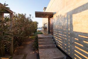 Dream house on Jose Ignacio Lagoon في خوسيه اجناسيو: درج يؤدي إلى منزل بجدار