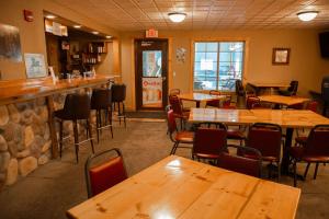 a restaurant with wooden tables and chairs and a bar at Deer Valley Lodge in Barneveld