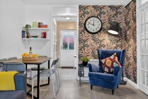een eetkamer met een tafel en een klok aan een muur bij Central Belfast Apartments, Salisbury in Belfast