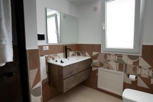 un bagno con lavandino e specchio di Marusu Apartments a Terrasini Altre 51 foto