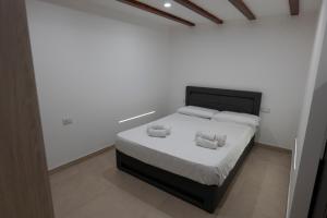 una camera da letto con un letto con due cuscini sopra di Marusu Apartments a Terrasini