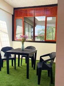 een eettafel met stoelen en een vaas met bloemen bij Leveli Coliving & Hostel Oaxaca in Oaxaca City