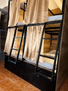 two bunk beds in a room with a window at Leveli Coliving & Hostel Oaxaca in Oaxaca City