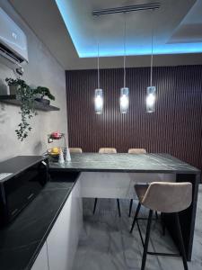 a kitchen with a table with chairs and lights at Studio apartman Luna in Vinkovci