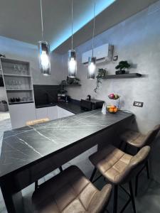 a kitchen with a black counter and some chairs at Studio apartman Luna in Vinkovci