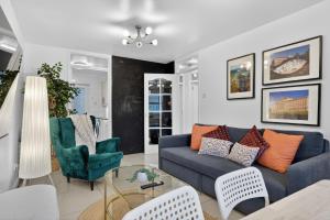 een woonkamer met een blauwe bank en stoelen bij Central Belfast Apartments, Salisbury in Belfast