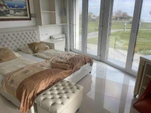 a bedroom with a bed and a couch and windows at Balatonparti Gyöngyszem in Keszthely