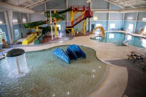 an indoor pool with a water slide and a water park at Deer Valley Lodge in Barneveld