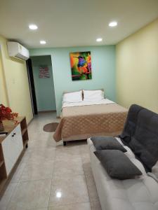 a living room with a bed and a couch at Ebratt Inn in Cartagena de Indias
