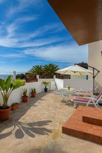 a patio with chairs and a table on a building at Casa Rural Encantadora Con Terraza Privada in Arona