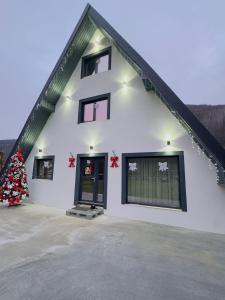 una casa bianca con un albero di Natale davanti di Sunny Hill Cab a Bulz
