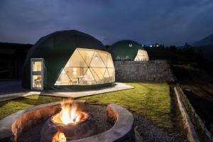 Permasalud Glamping : خيمة على شكل قبة في فناء به موقد نار