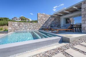 a villa with a swimming pool and a patio at Ariadne Suites in Mytakas