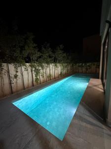 a swimming pool lit up at night at Luxury Villa Marrakech in Marrakesh