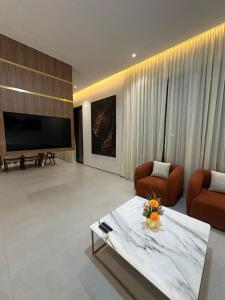 a living room with a large television and a couch and chairs at Luxury Villa Marrakech in Marrakesh