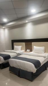 two beds in a hotel room with two at فندق اجنحة السمو إن in Aḩad al Masāriḩah