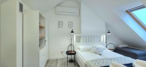 a small bedroom with a bed and a chair at Apartament Lubię Morze by TriApart in Jantar