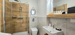 a bathroom with a shower and a toilet and a sink at Apartament Lubię Morze by TriApart in Jantar +33 photos