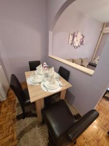 comedor con mesa con sillas y espejo en Stan na dan DN-apartman, en Kula