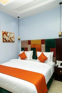 a bedroom with a large bed with orange and white pillows at Kaashmeen Hotel & Suite in Lagos