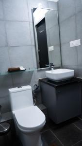 Trisara Boutique Stay في ميسور: حمام مع مرحاض ومغسلة ومرآة