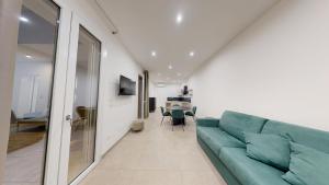 a living room with a green couch and a table at MarèA25 in Porto Cesareo