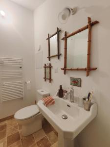 a white bathroom with a toilet and a sink at Maison d'hôtes La bien-Aimée in Montrevault