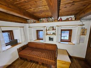 Habitación con sofá en una habitación con ventanas en Hiška Polhec, en Bovec 3 fotos más
