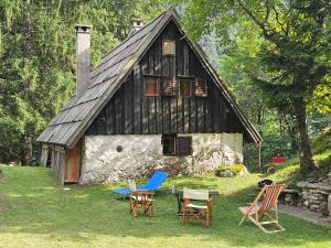 uma casa antiga com cadeiras de balanço na frente dela em Hiška Polhec em Bovec