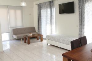 Sala de estar con cama, sofá y mesa en Holiday Luxury Villas, en Kalamaki