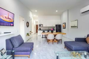 een woonkamer met paarse meubels en een tafel bij Morgan Hotel Boutique & Residences, Los Cabos in Cabo San Lucas