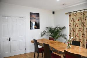 a dining room with a wooden table and chairs at Loop Head Lodge Carrigaholt 4 bedroom self catering holiday home in Carrigaholt +27 photos
