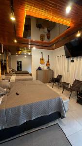 a bedroom with two beds and guitars on the wall at Hotel KK 1021 in Coxim