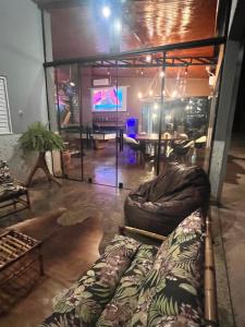 a living room with a couch in front of a screen at Hotel KK 1021 in Coxim