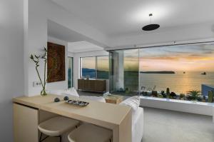 un soggiorno con un tavolo e una grande finestra di Endless Blue a Sarakíniko