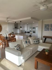 a living room with a white couch and a kitchen at Estepona Beach Frontline Deluxe 3BR Condo in Estepona