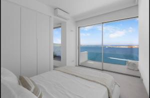 una camera da letto con un letto e una grande finestra di Endless Blue a Sarakíniko