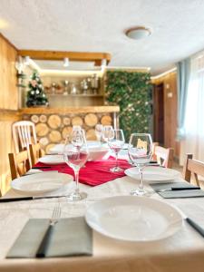 a table with plates and wine glasses on it at Guest House Rila in Govedartsi