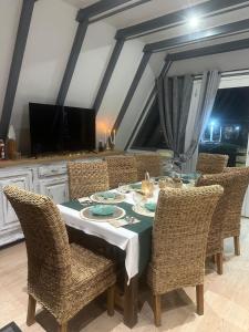 ein Esszimmer mit einem Tisch mit Korbstühlen in der Unterkunft L'armorique in Saint Die