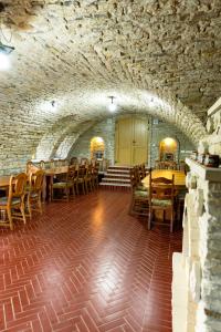 ein Speisesaal mit Tischen und Stühlen in einem Steingebäude in der Unterkunft La Badea Mircea in Soroca