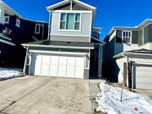 a house with a garage door in the snow at Global Family Canada in Calgary