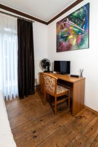 a desk with a computer on it in a room at Pension zur Schleuse Kleinmachnow in Kleinmachnow +23 photos