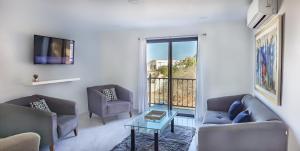 een woonkamer met twee banken en een tafel bij Morgan Hotel Boutique & Residences, Los Cabos in Cabo San Lucas