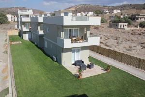 a house with a green lawn in front of it at Holiday Luxury Villas in Kalamaki