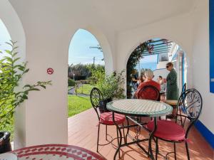 a man sitting at a table on a patio at Quinta do Canal in Vila Nova de Milfontes