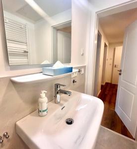 Ferienwohnung "Seeruhe" - Berge, See und Natur am Spitzingsee في شليرزيه: حمام أبيض مع حوض ومرآة