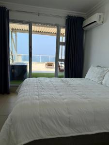 een slaapkamer met een bed en uitzicht op de oceaan bij 101 Camarque - 3 Bedroom Apartment In Umdloti - 180 Degree Sea Views in Umdloti +67 foto's