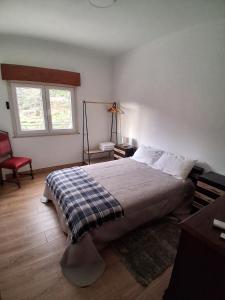 a bedroom with a bed and a chair and a window at Piscinas, Serra da Estrela AL in Bouça