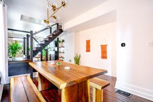 a dining room with a wooden table and a staircase at Jungle House Luxury Stays - Columbus Downtown Short North in Columbus